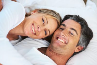 Happy mature couple lying in bed together